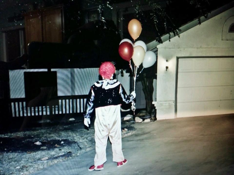 The clowns are holding balloons