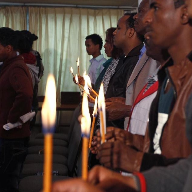 Eritrean people hold candles during a memorial gathering to mark the first anniversary of the Lampedusa migrant shipwreck.