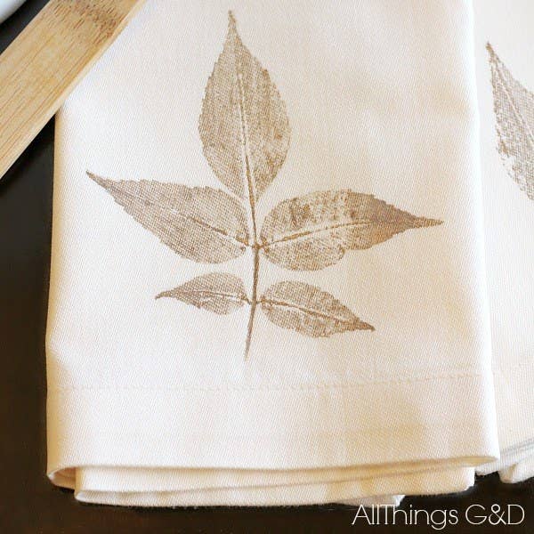 You don't have to spend much for a gorgeous fall table. Just use gold paint and leaves to stamp cream colored napkins. Everyone will think you spent a fortune. Joke's on them.
