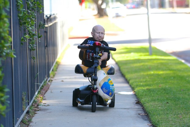 Verne Troyer carrying a turkey.