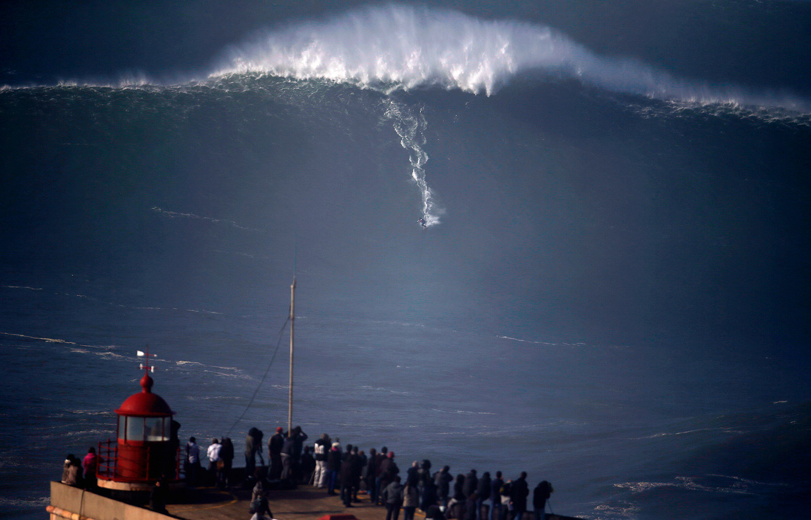 A surfer drops in on a large wave at Praia do Norte, in Nazare on Dec. 11.