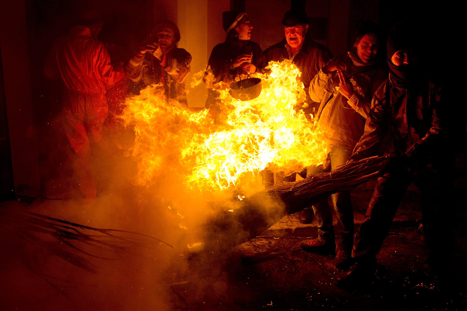 A reveler hits a family with a burning broom during the "Los Escobazos" Festival on Dec. 7 in Jarandilla de la Vera, Spain.
