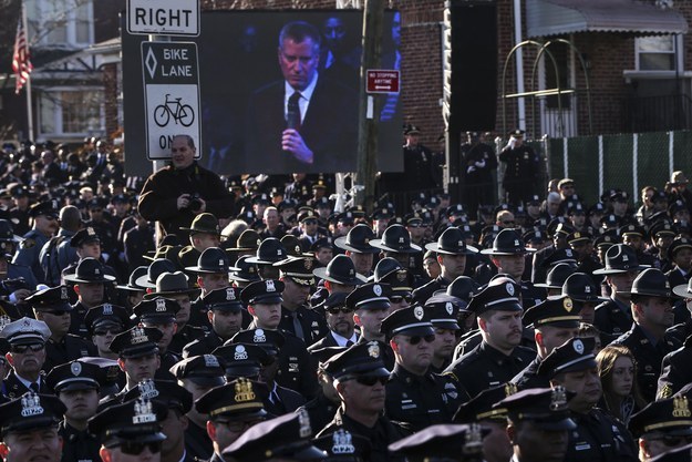Law enforcement officers turn their backs on a live video of de Blasio speaking speaks at the funeral of slain officer Rafael Ramos on December 27.