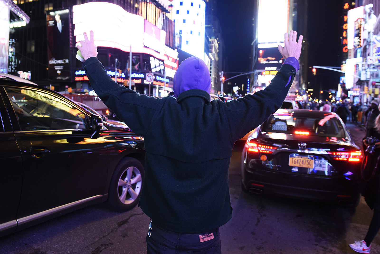 A protester walks through traffic in Times Square.