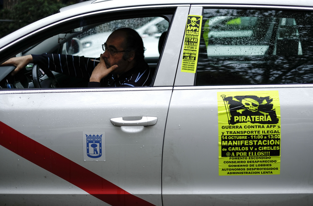 A taxi driver sits in his car as he takes part in a protest against Uber in Madrid on Oct. 14.
