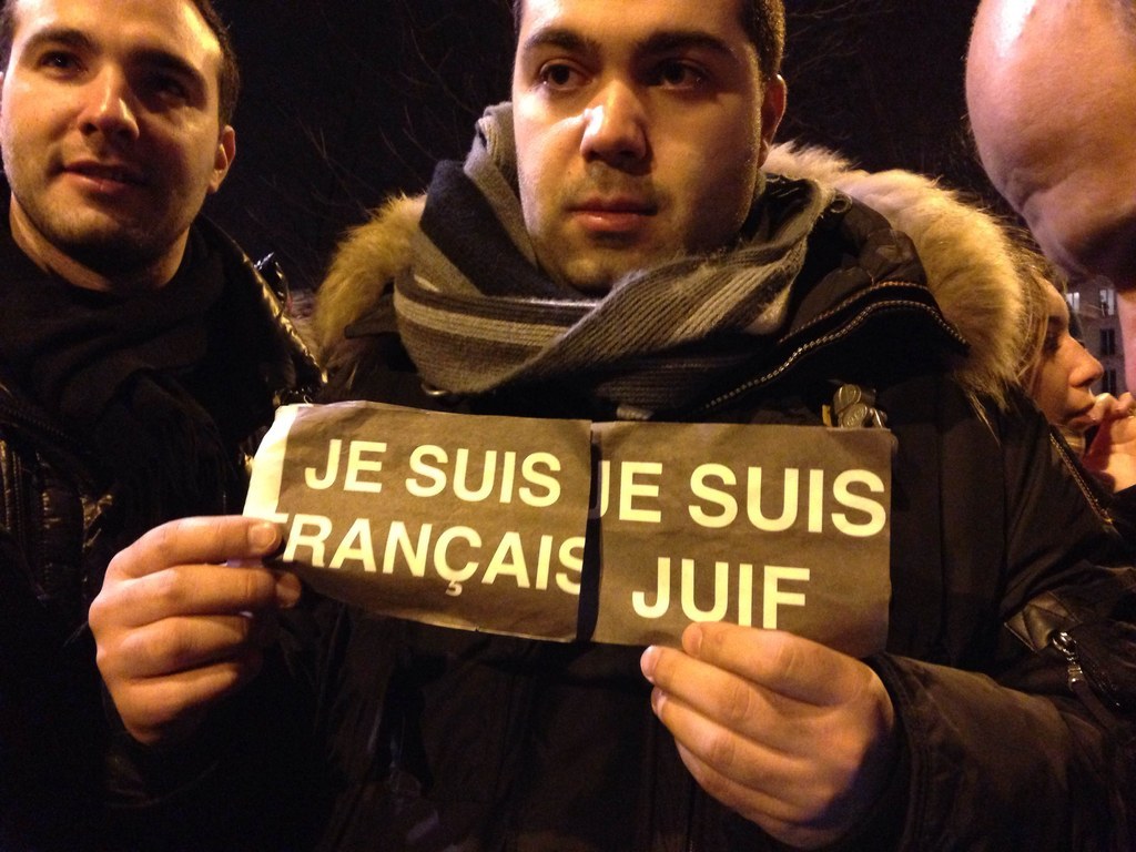 A protester carries two signs saying "I am French" and "I am Jewish."