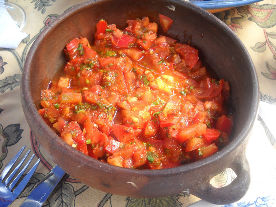 What is it?Pebre is a condiment that is popular in Chile made from coriander, onions, olive oil, garlic and aji peppers. For the uninitiated, aji peppers are also known as Peruvian hot peppers, and are medium heat peppers, rating about 40k on the Scoville chart. Recommended uses:Chileans typically spread pebre on barbecued meat dishes, so keep it in mind next time you're grilling.