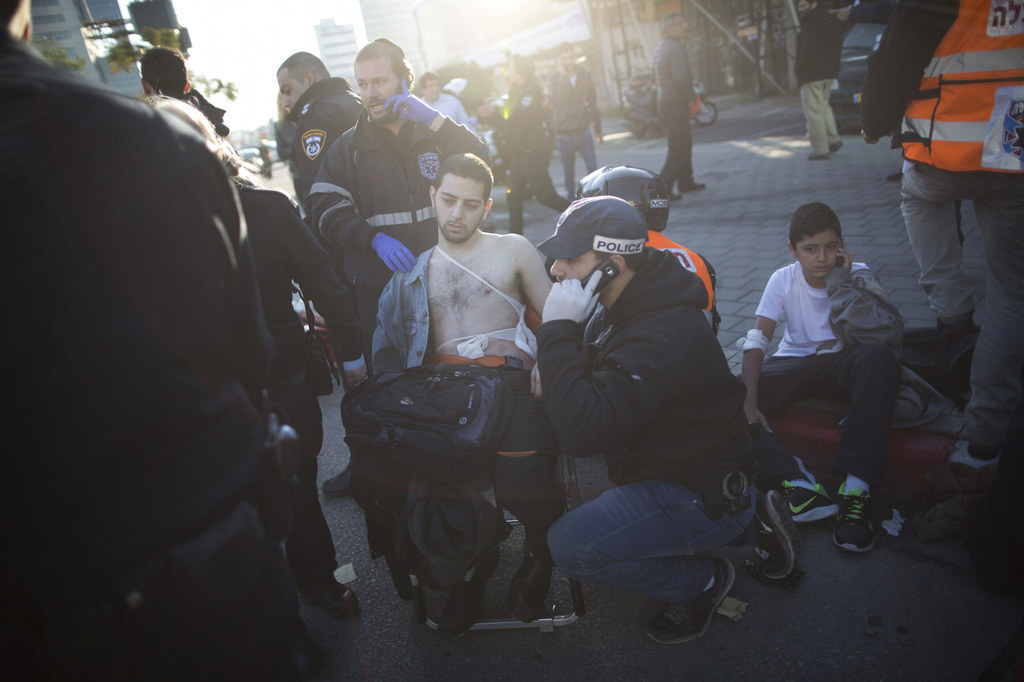 An Israeli police officer and paramedics treat an injured man at the scene of a stabbing in Tel Aviv, Israel, on Jan. 21.