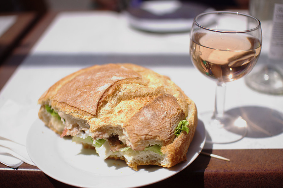 The pan-bagnat is a popular sandwich in Nice, France. The sandwich is composed of a round, white bread and a salad of raw vegetables, hard boiled eggs, anchovies, tuna, and olive oil.