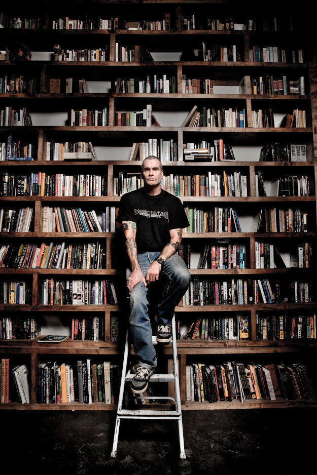 Henry Rollins sits in front of his personal book collection (which includes Tolstoy, Twain, Rimbaud, Proust, Capote plus book on Sinatra, Encyclopedia of 60s Jazz as well as Iggy Pop and AC/DC; take a closer look at all of the titles here). Henry Rollins on writing: "I have burned more hours than I would like to admit in slow agony, ransacking my brain for an idea to write about...The first draft is handwritten and then, often moments later, is rewritten into a computer for the second draft and worked on from there. When I am off the road, this is often my big Friday night out."In addition to publishing books, Rollins writes for the LA Weekly.