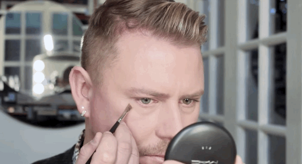 Use a small, angled concealer brush and a shade of cream-based concealer that matches your skin tone. Apply the concealer just in the shadow (or crease) of the bag under your eye, not to the bag itself. To see the entire trick, watch the tutorial here.