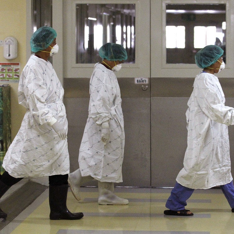 Thai healthcare workers walk in the isolation ward.
