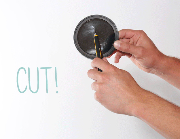 Protect your hands from paint splatter. Cut a slit through a plastic lid like those you find on coffee cans and slide your brush through.