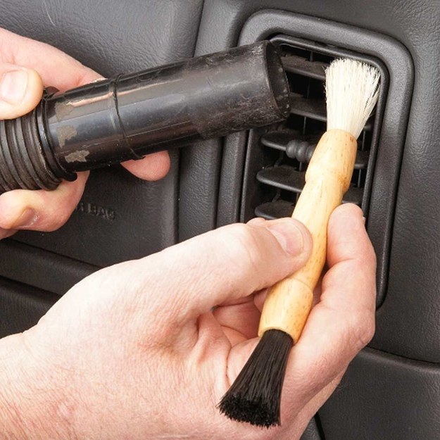 Vacuum up the dust as you brush it off, so it doesn't immediately settle somewhere else in the car.