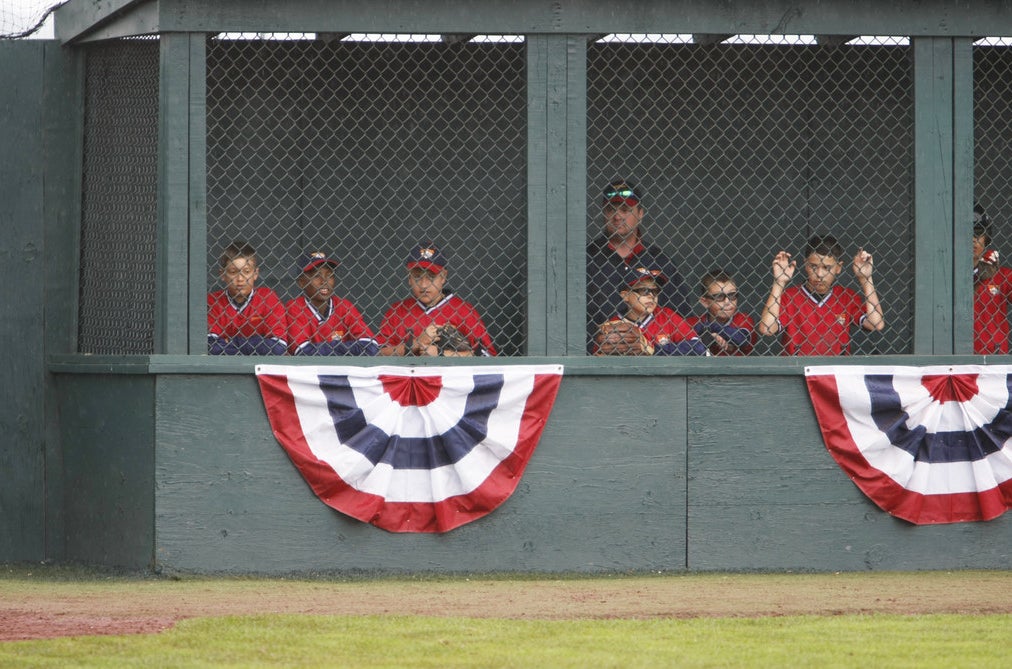 Kids in dugout because of rain delay.