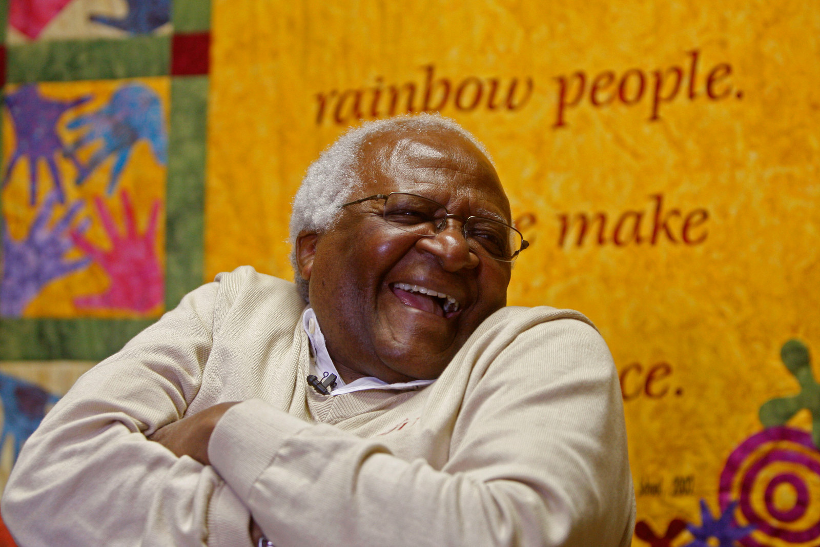 A smiling Tutu with his armed folded in front of him