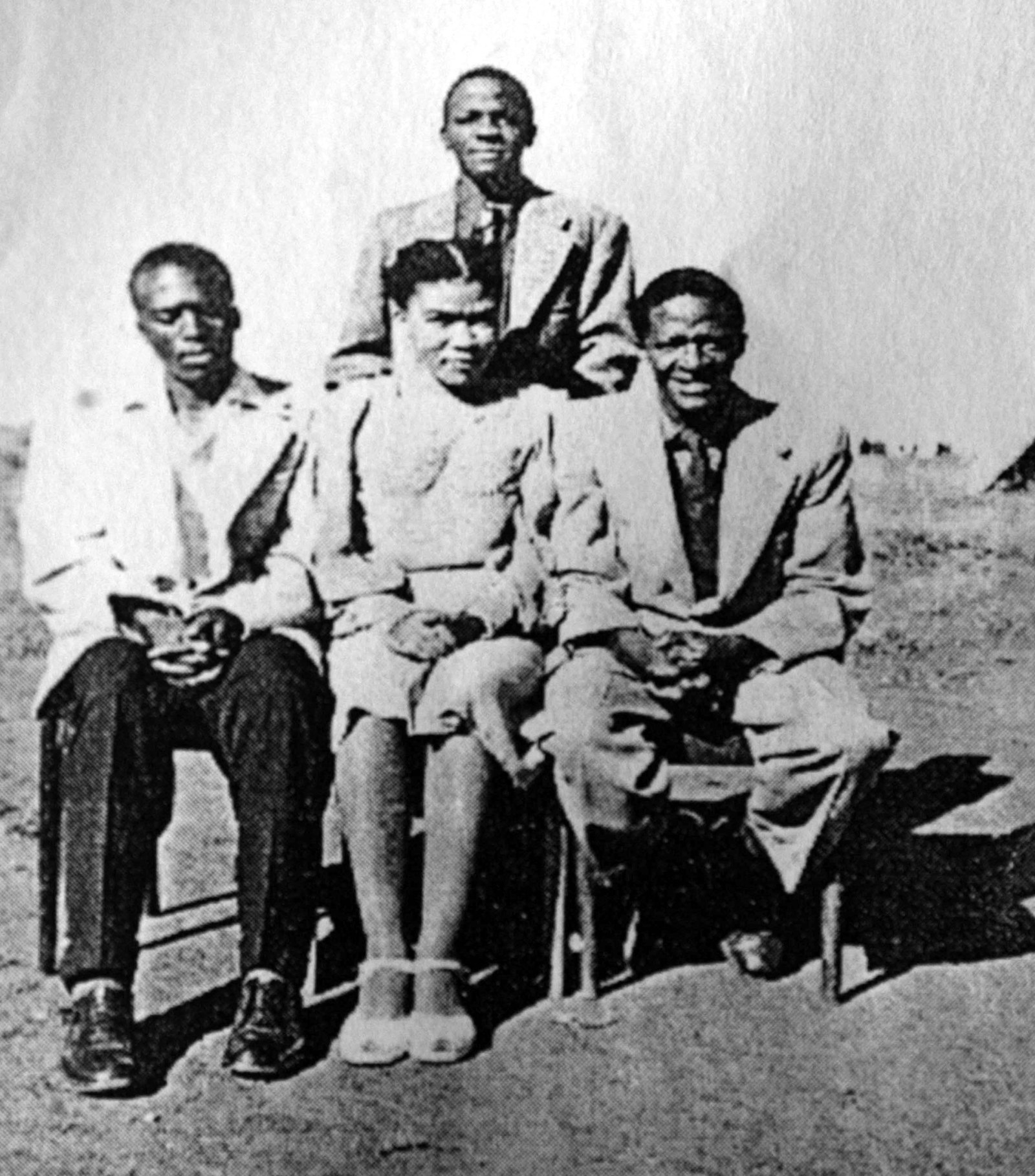 Four people — three men and a woman — sitting next to each other