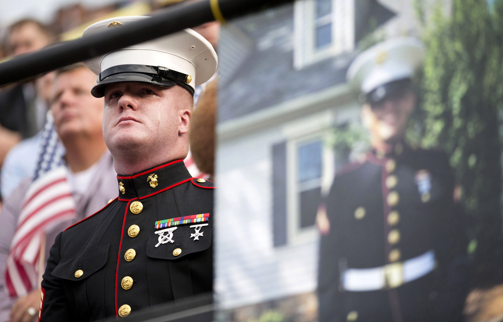 A tear rolls down the cheek of Sgt. Benjamin Tranter, a former classmate of Lance Cpl. Squire Wells seen in the right-hand photo, as he attends a memorial service for Wells at Sprayberry High School where they both attended. Crowds gathered at the suburban Atlanta high school to remember the Marine who was fatally shot in an attack on military facilities in Chattanooga, Tennessee.