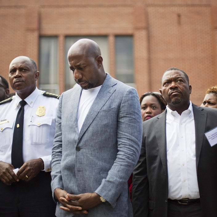 Rev. Raphael G. Warnock, pastor of Ebenezer Baptist Church, center left, waits with Atlanta Police Chief George Turner, left, to speak at a news conference.