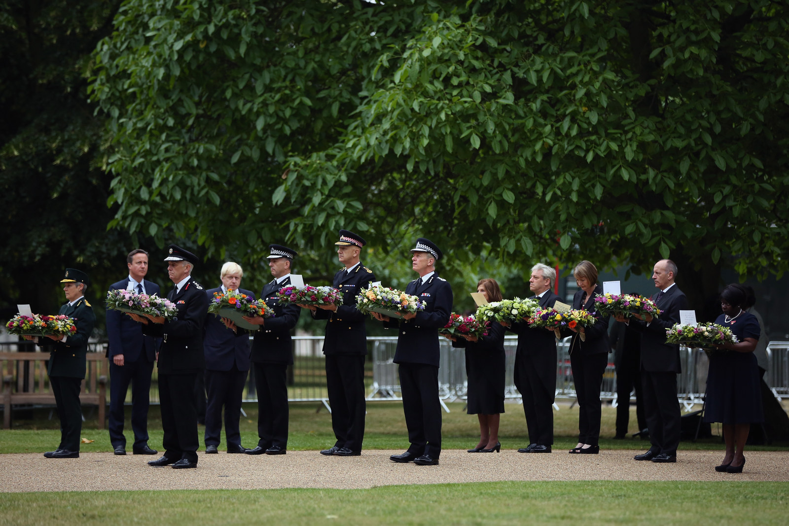 Ambulance, fire, and police representatives are joined by British prime minister David Cameron and London mayor Boris Johnson in Hyde Park.
