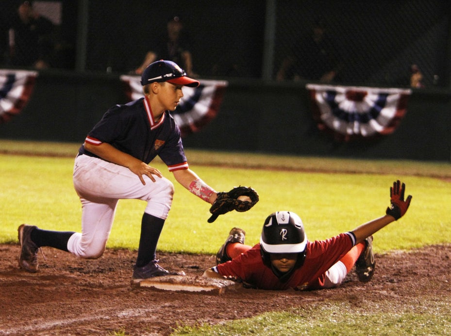 Nathan Schollar slides into third base before begin tagged out.