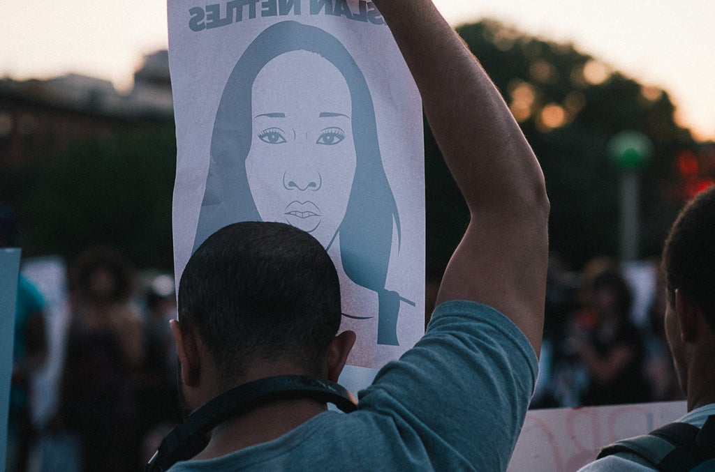 A man holds a poster of Islan Nettles.