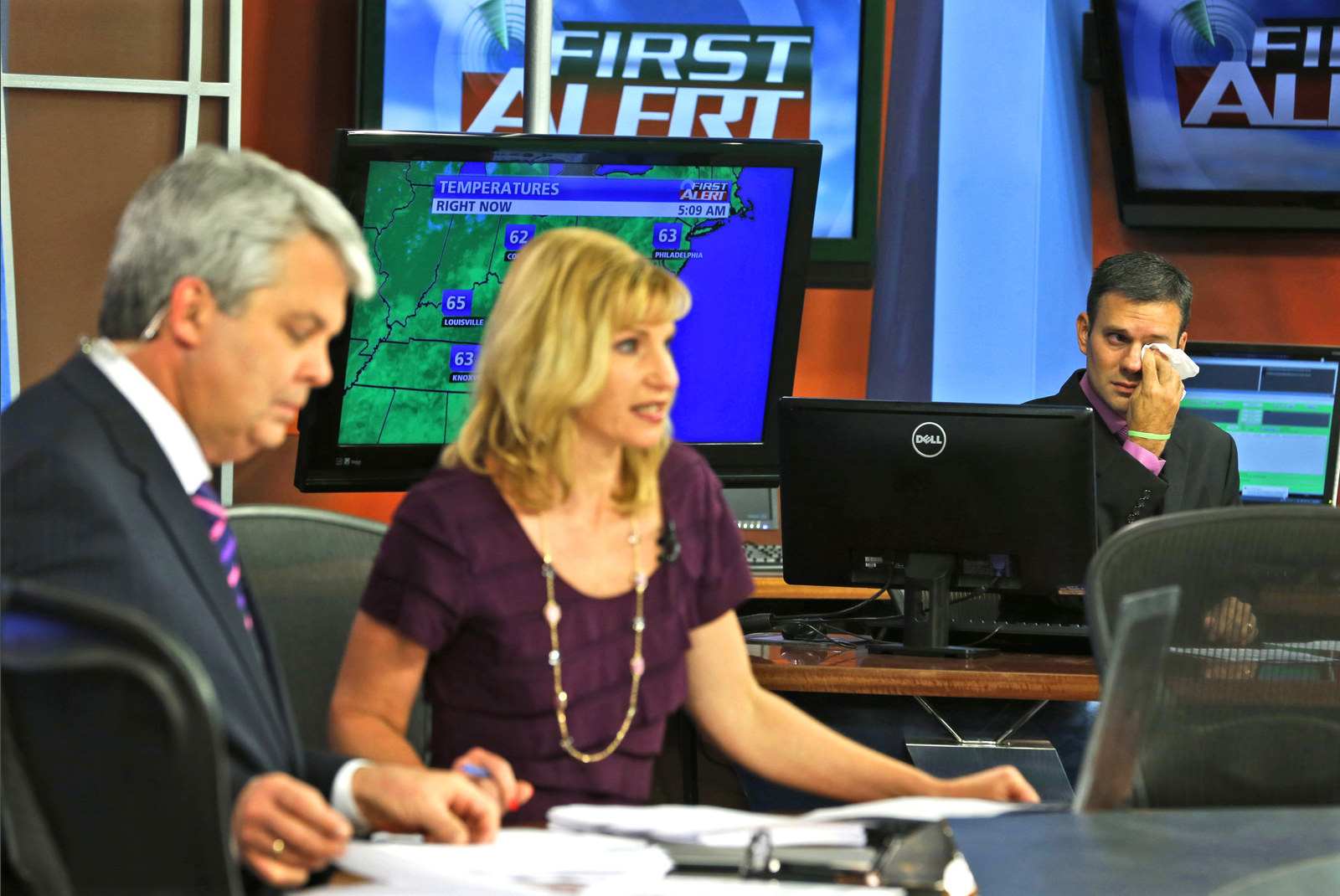 WDBJ-TV7 meteorologist Leo Hirsbrunner wipes his eyes during the early morning newscast as anchors Kimberly McBroom and Steve Grant deliver the news. Tragically, reporter Alison Parker and cameraman Adam Ward were killed during a live broadcast Wednesday, while on assignment in Moneta.