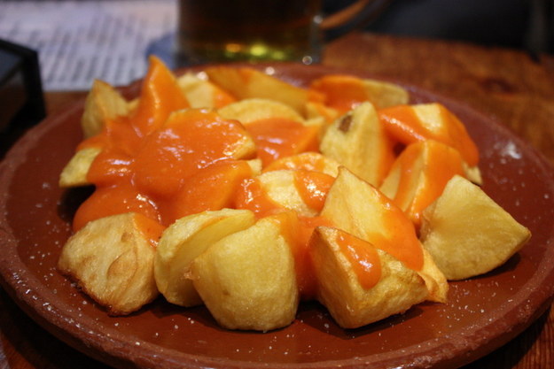 White potatoes that have been cut into irregular shapes of about 2 centimeters, then fried in oil and served warm with a sauce such as a spicy tomato sauce or an aioli.