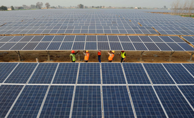 Indian workers construct part of the France-India Solar Direct Punjab Solar Park project in Muradwala.