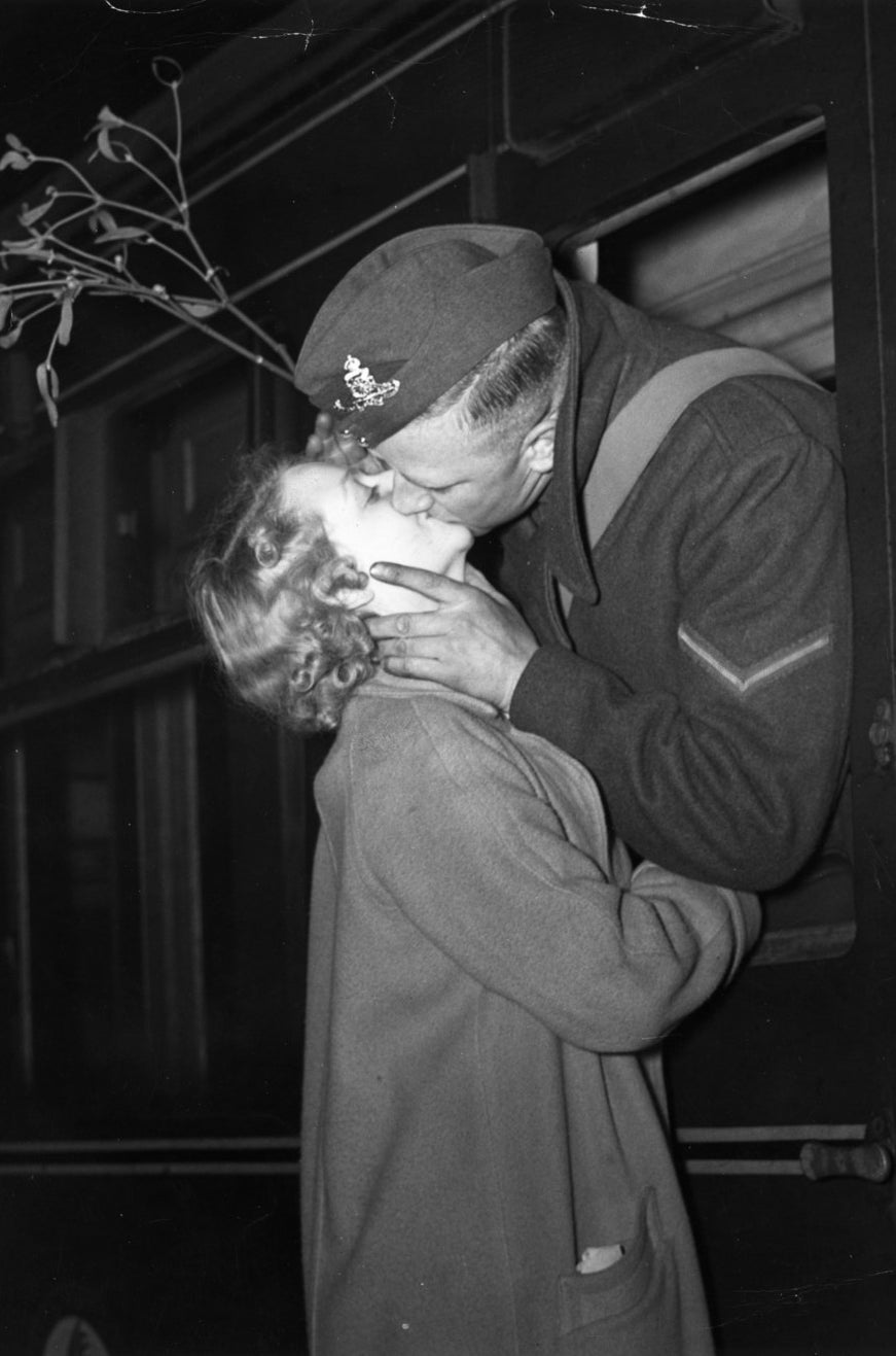 Un soldado que parte de una estación de ferrocarril en Londres para reunirse con su pelotón se llevó consigo una rama de muérdago para asegurarse de recibir su beso de Navidad. Diciembre, 1939.
