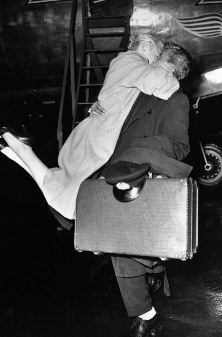 A woman greeting her Skymaster Aircrew husband with enthusiasm after his flight to Albania.