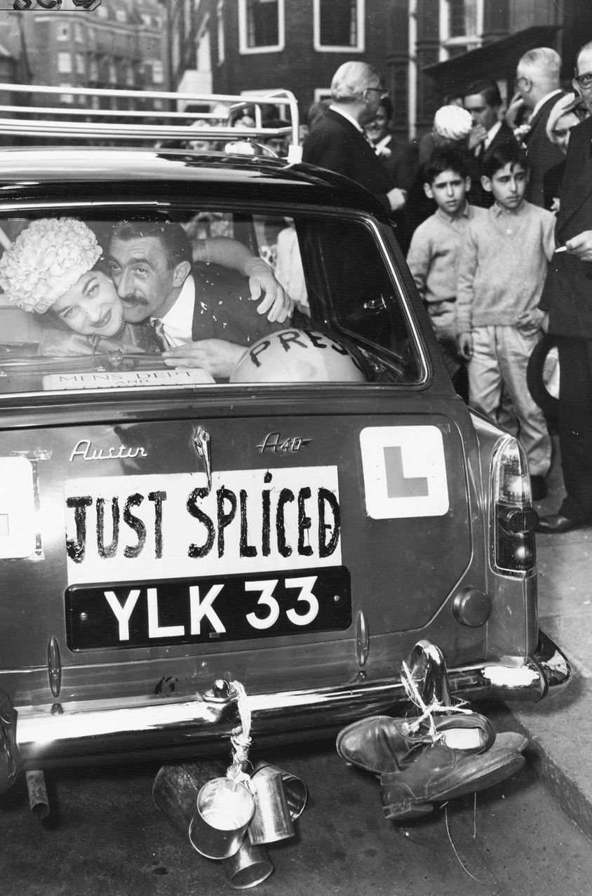 El comediante Mario Fabrizi y su nueva esposa Kathleen, sonriendo en la parte trasera de su coche de bodas en Caxton Hall, Londres. Mayo, 1960.