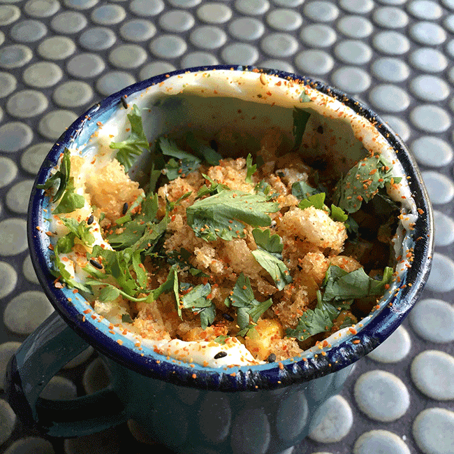 Común chef Chad White puts a unique twist on a Mexican favorite. Charred corn is seasoned with butter, lime, and onions and tossed in a mayo-lined mug topped with cilantro and chicharrones. Corn never looked (and tasted) so good!