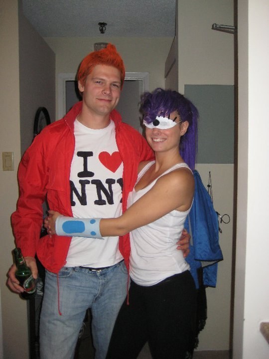 Man with red hair and red jacket and girl with purple hair and one eye