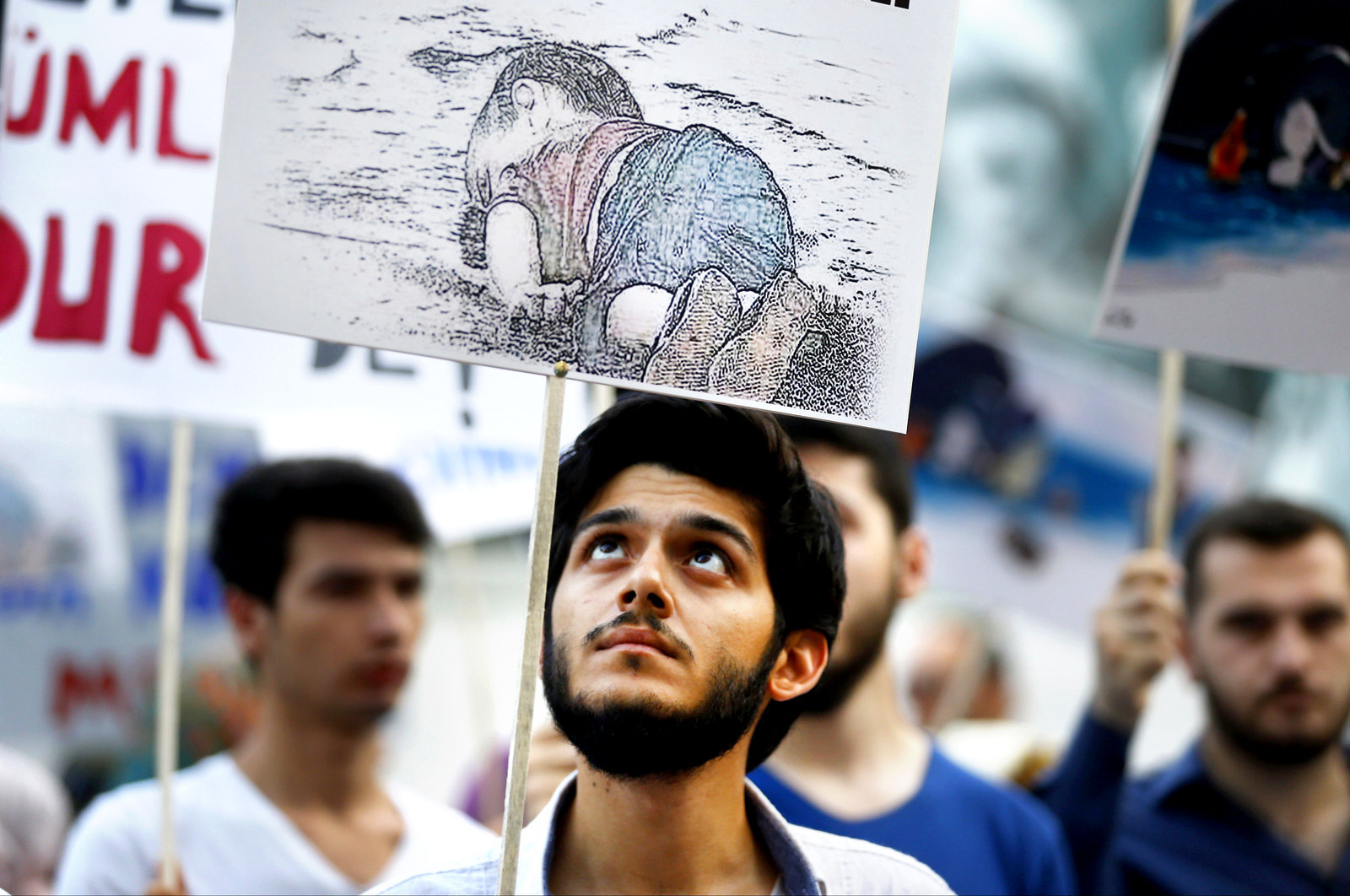 A man holds a poster with a drawing depicting a drowned Syrian toddler during a demonstration for refugee rights in Istanbul, Turkey. The image of Aylan Kurdi went viral on social media and piled pressure on European leaders. The Kurdi family had been trying to emigrate to Canada after fleeing the war-torn town of Kobani, a revelation which also put Canada's Conservative government under fire from its political opponents.