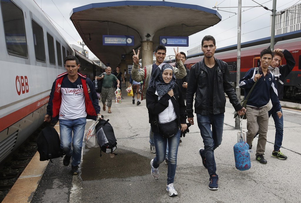 Refugees run to reach a train in Vienna, Austria, Saturday.