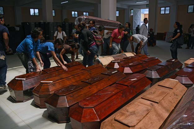 Gente carga ataúdes donados para las víctimas del deslave.