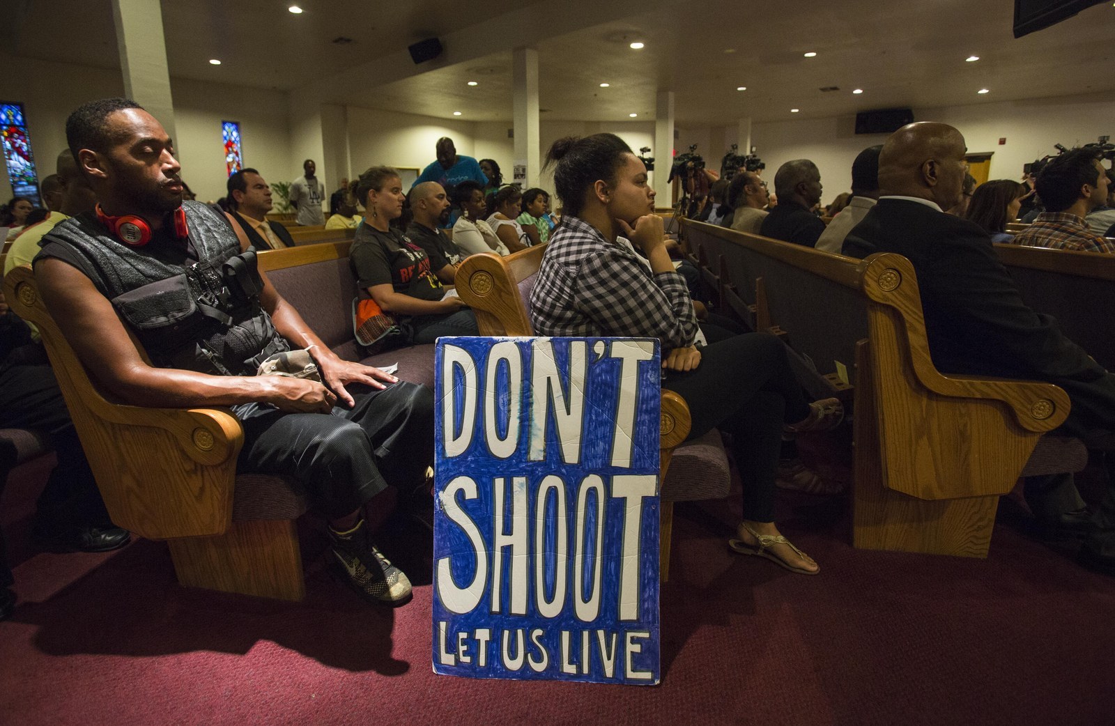 People gather inside Paradise Baptist Church during a community forum Tuesday, Aug. 19, 2014, in Los Angeles, to discuss the police shooting of 25-year-old Ezell Ford.