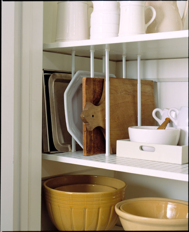 Use tension rods to store your cutting boards and baking sheets so they're easily accessible.