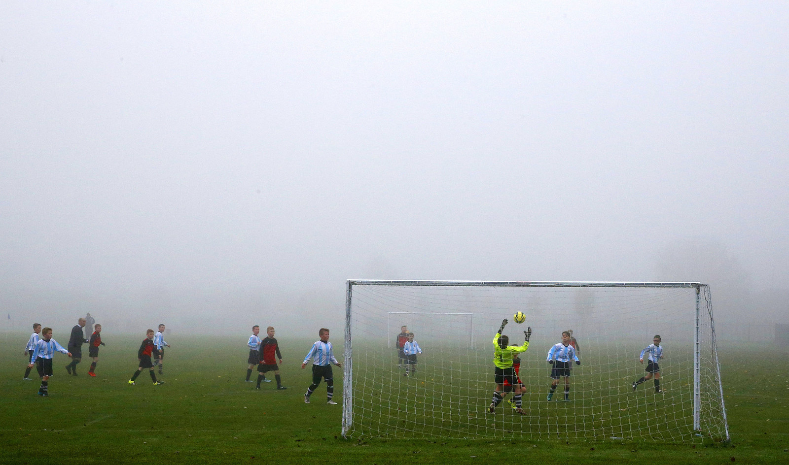 Children play a Sunday League football match during low fog in Netherley, Liverpool, 1 November.
