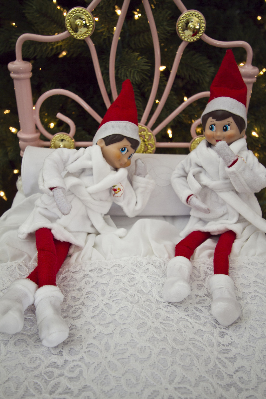 Two elves lying on a bed and wearing robes