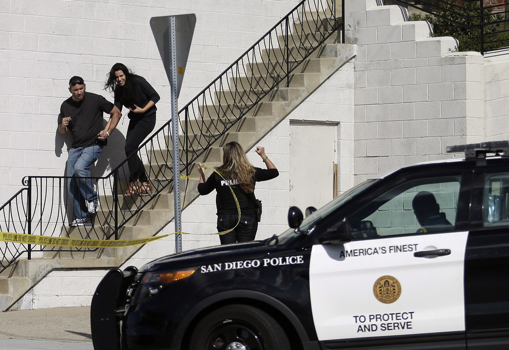 San Diego police officers assist a couple as they evacuate a building.