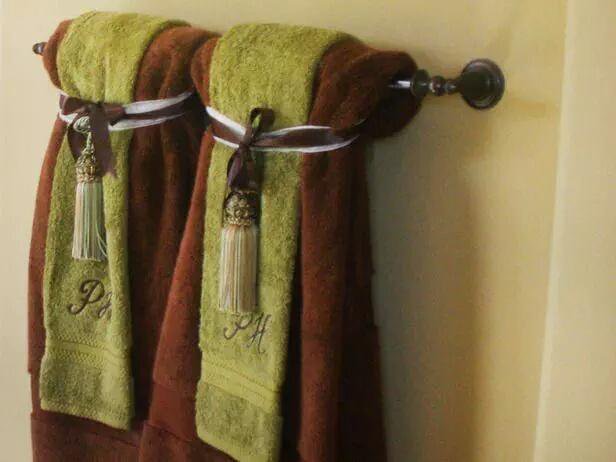 Fancy brown and green towels hanging on a towel bar