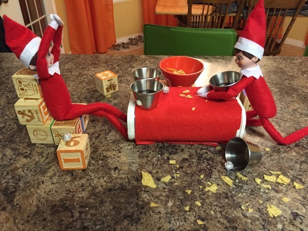 Two elves with buckets of syrup and one taking aim