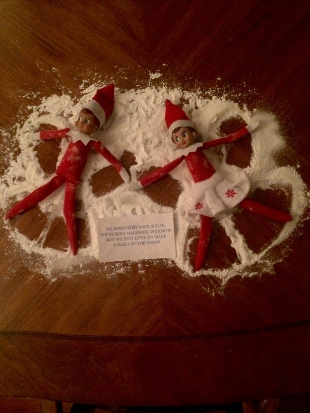 Two elves lying with their arms and legs stretched out and surrounded by &quot;snow&quot; sugar and a note saying that they&#x27;ve been &quot;naughty&quot; because they stole the sugar