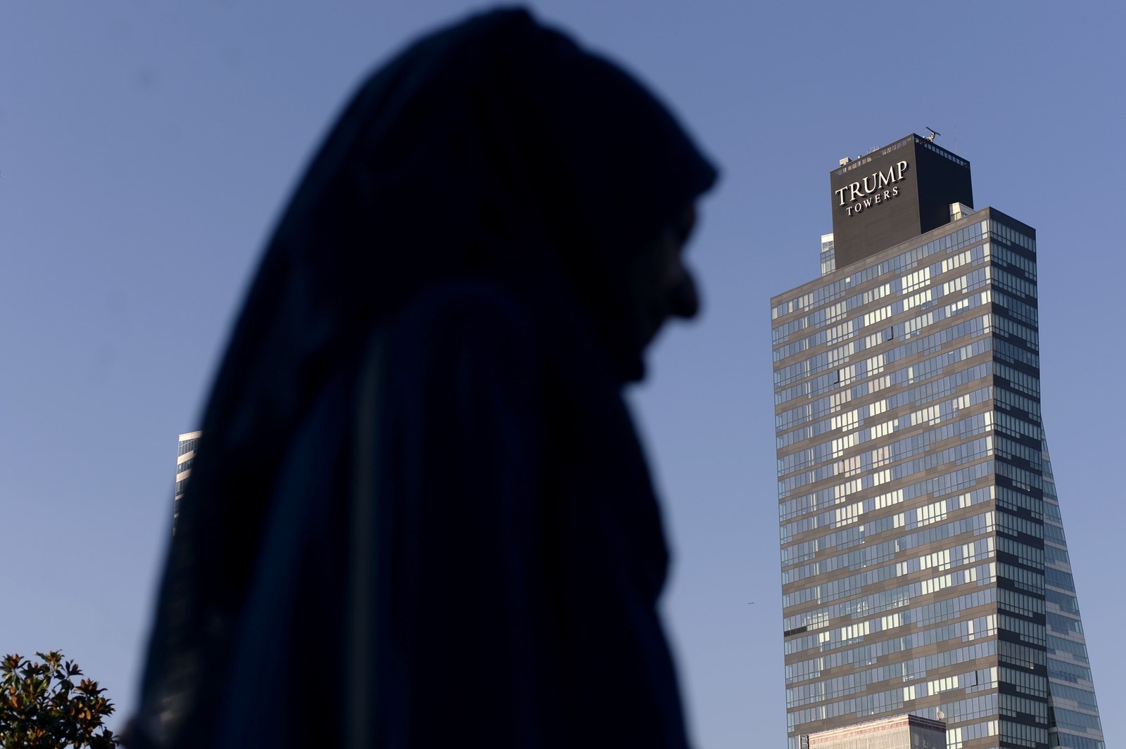 A woman walks past the Trump Towers building in Istanbul