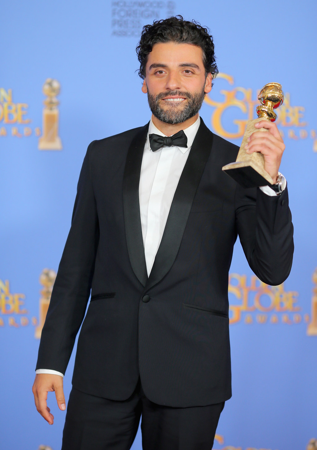 9 Photos Of Oscar Isaac Proudly Gazing At His Golden Globe