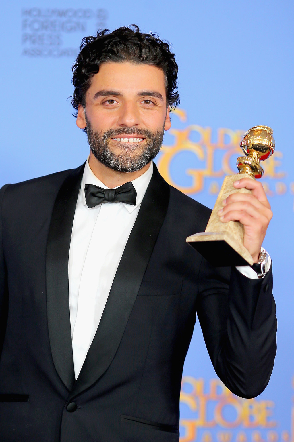 9 Photos Of Oscar Isaac Proudly Gazing At His Golden Globe