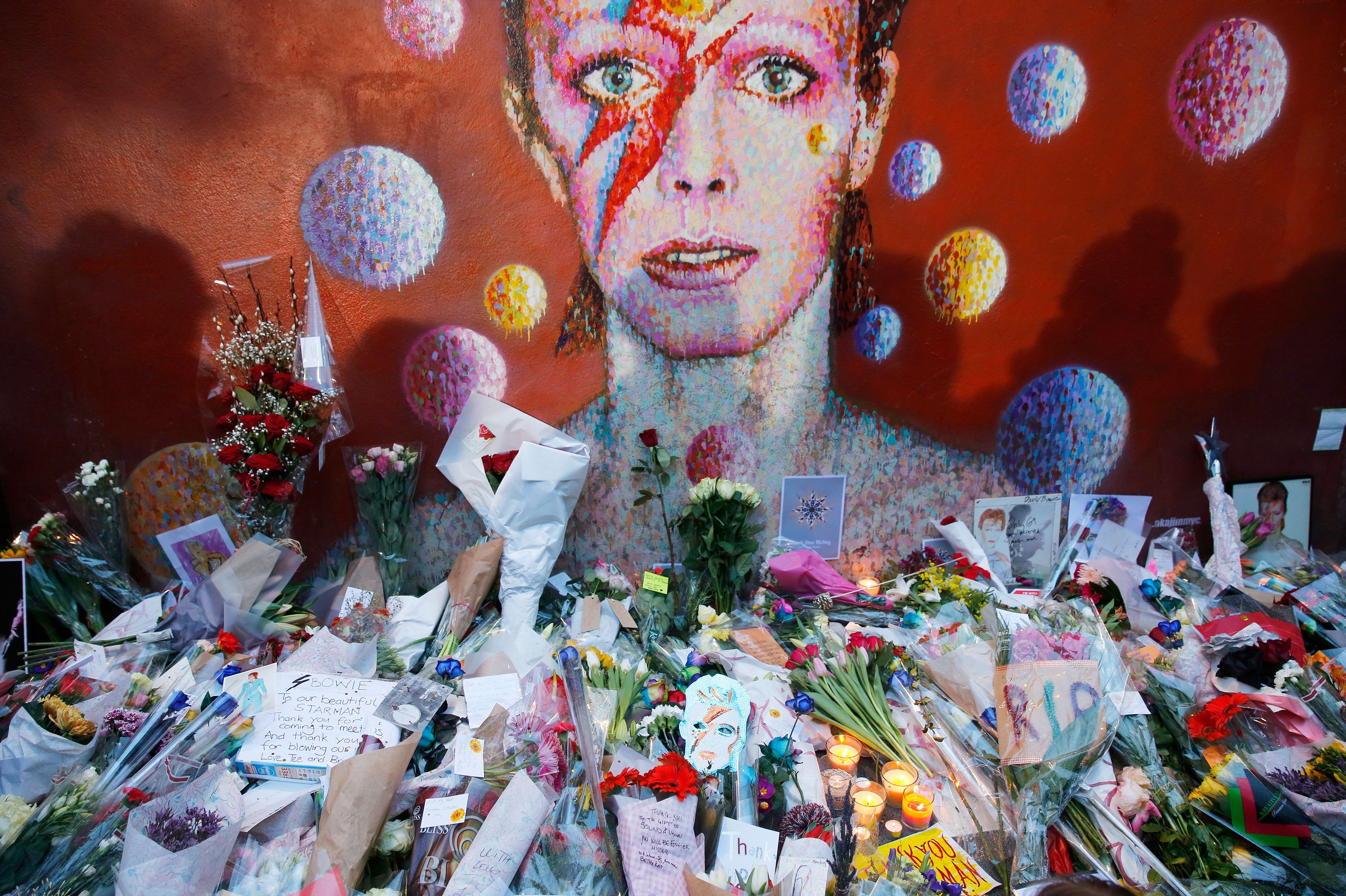 Flowers and tributes lie at a mural of David Bowie in Brixton, south London.