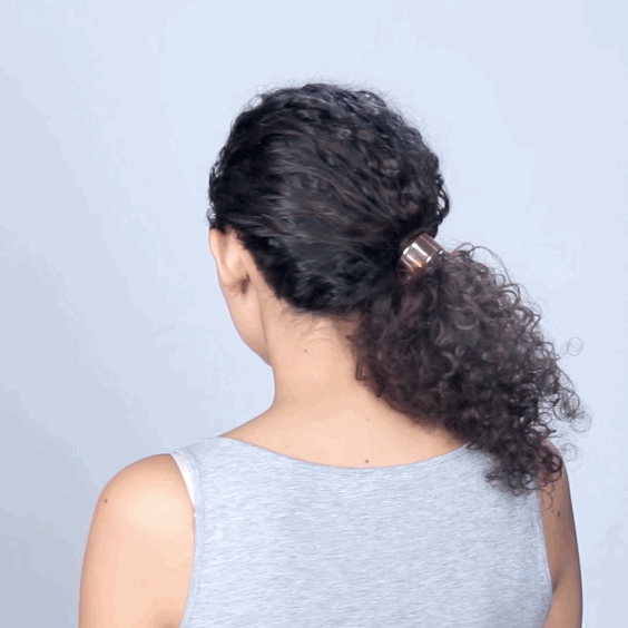 How to get the look:1. Pull curls around to one side, so they sit low on your neck, adjacent to your ear. Pull out about an inch of hair from the front top section, secure the remaining hair with a pony tail.2. Connect the loose section of hair to your pony tail using bobby pins.3. Create added volume by using a pick to pull out some of your curls.